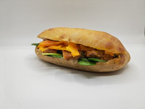 Sandwich garni de bâtons au poisson, carottes et de mâches.